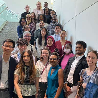 NIMHD’s 2024 postbacs stand with their mentors on a staircase